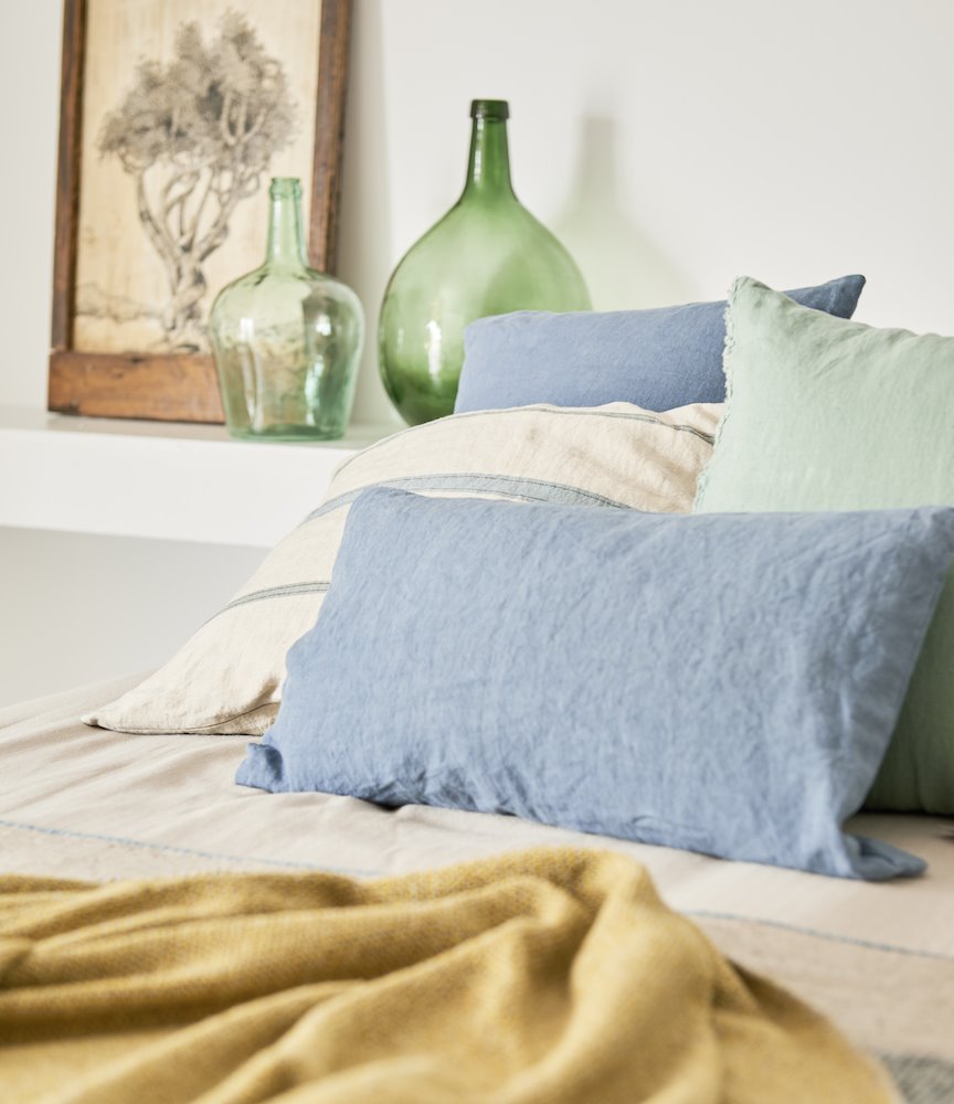 Dormitorio con cojines de lino azul y de rayas