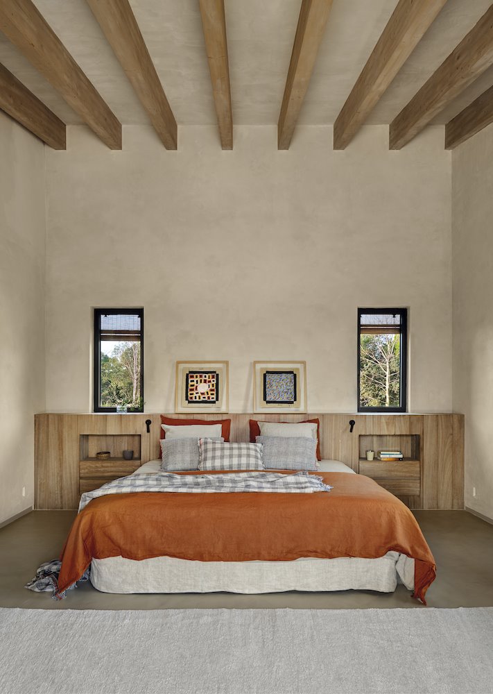 Dormitorio con vigas y ropa de cama terracota