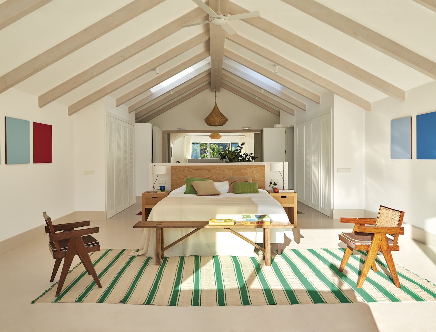 Dormitorio moderno con vigas en el techo y alfombra de rayas verdes