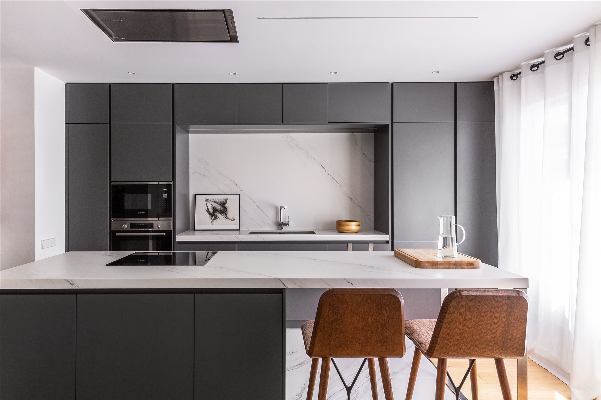 Piso reformado en Barcelona con mucha luz cocina con taburetes altos