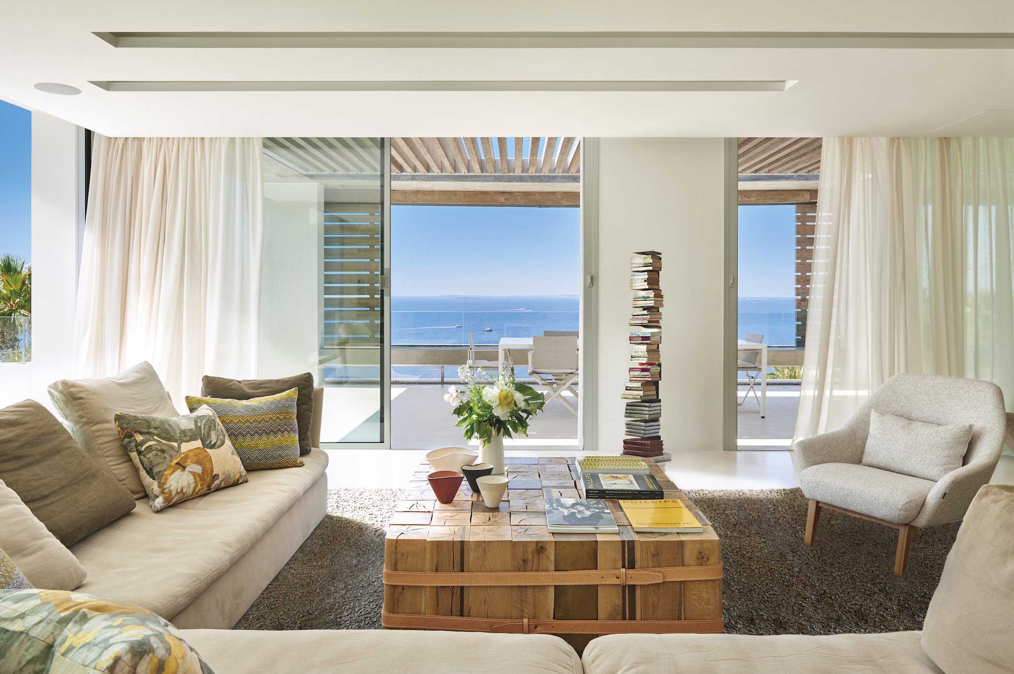 salon abierto con vistas al mar y cortinas blancas