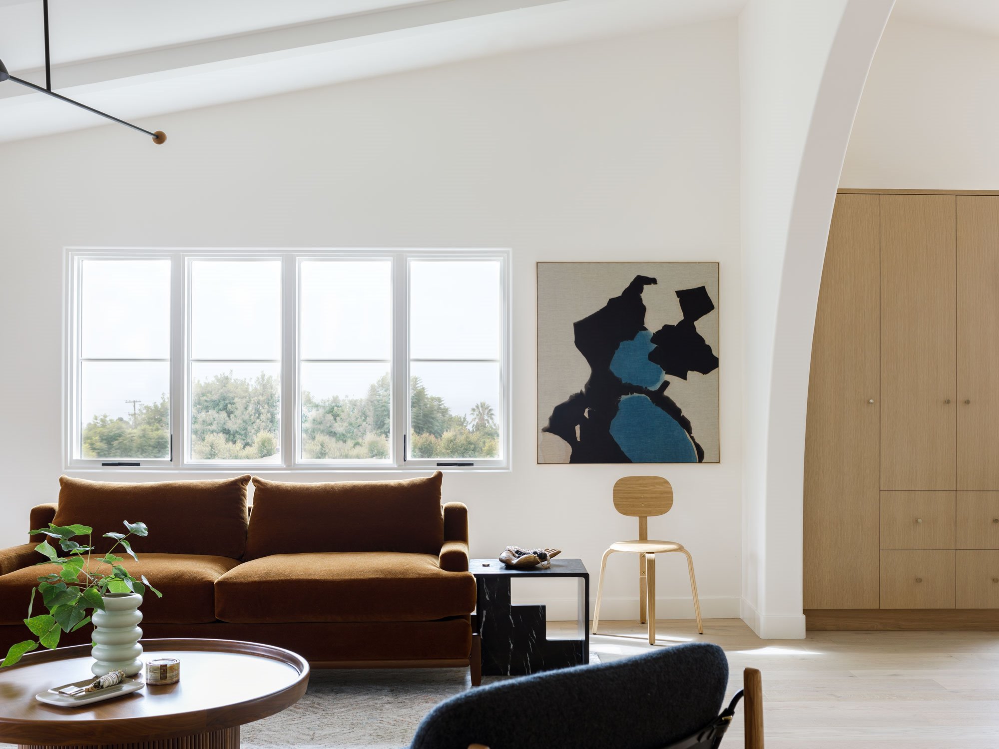 Casa moderna con arcos en LA salon con sofa marron y cuadros