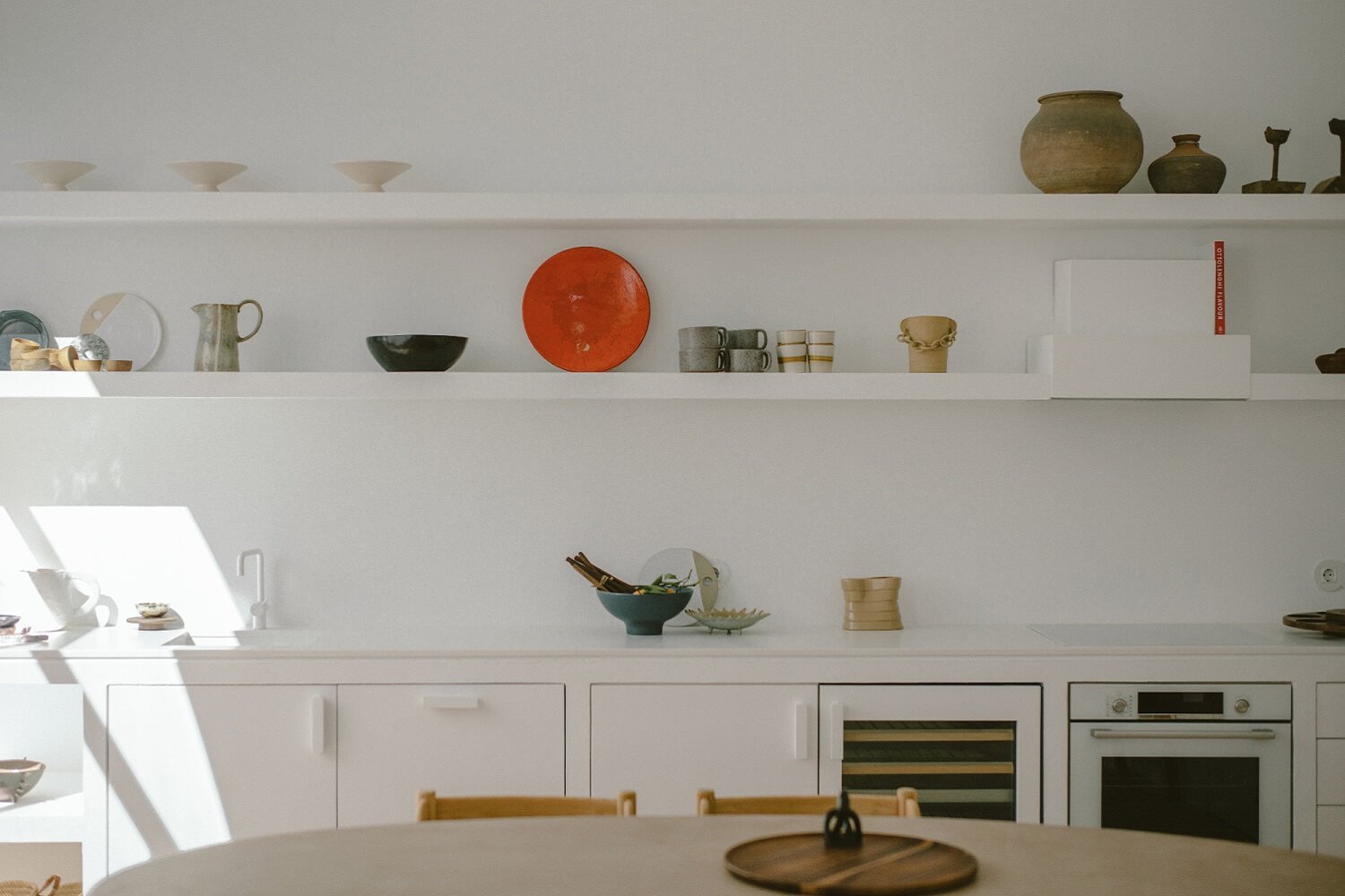 Cocina blanca con estantería de obra en Casa Dois en Portugal