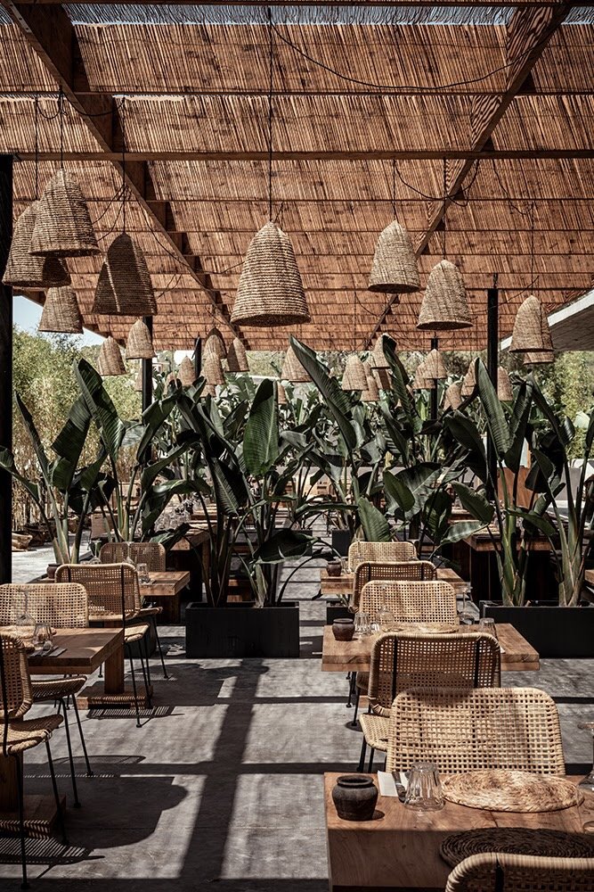 Terraza del OKU Restaurant con mobiliario de mimbre luces y sombras