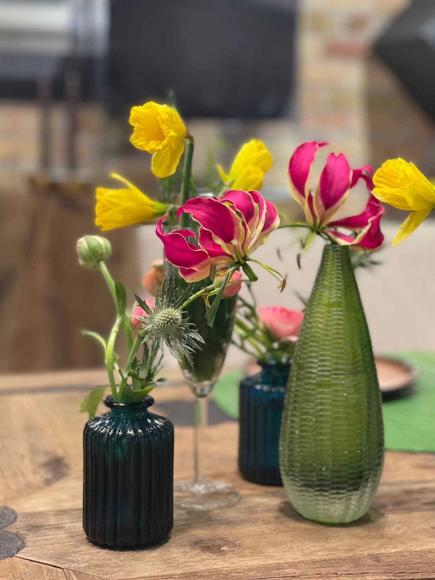 Ramos de flores rojas y amarillas hechos sobre botellas de vidrio. Aprovecha lo que tienes en casa