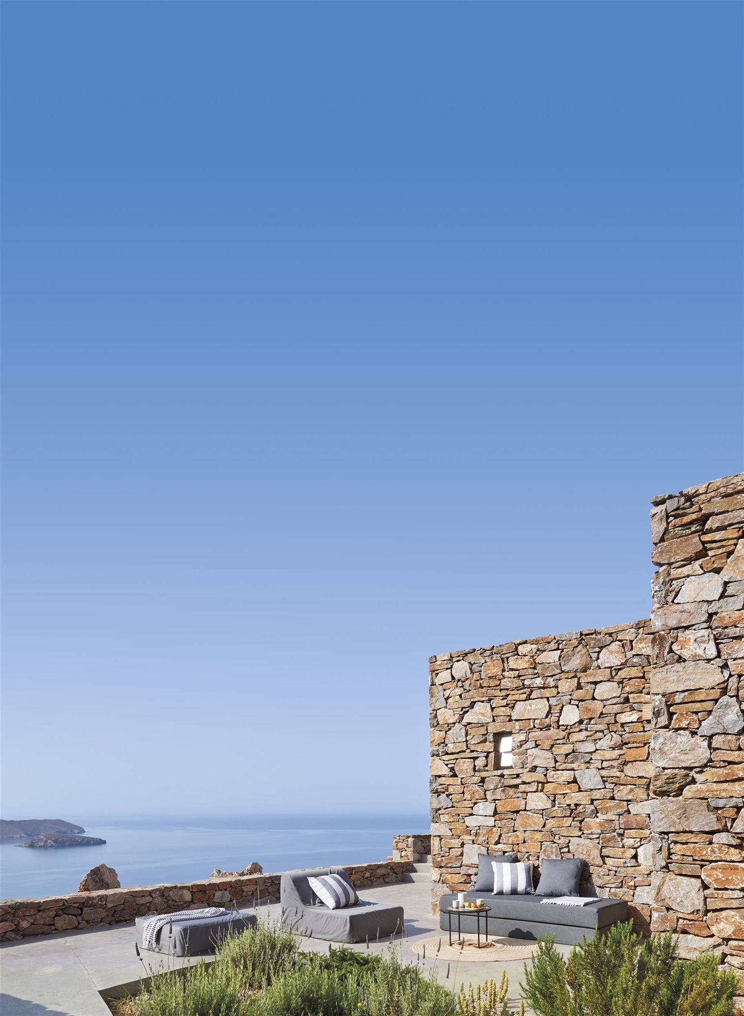 porche de una casa de verano con muros de piedra. Abre la casa al exterior
