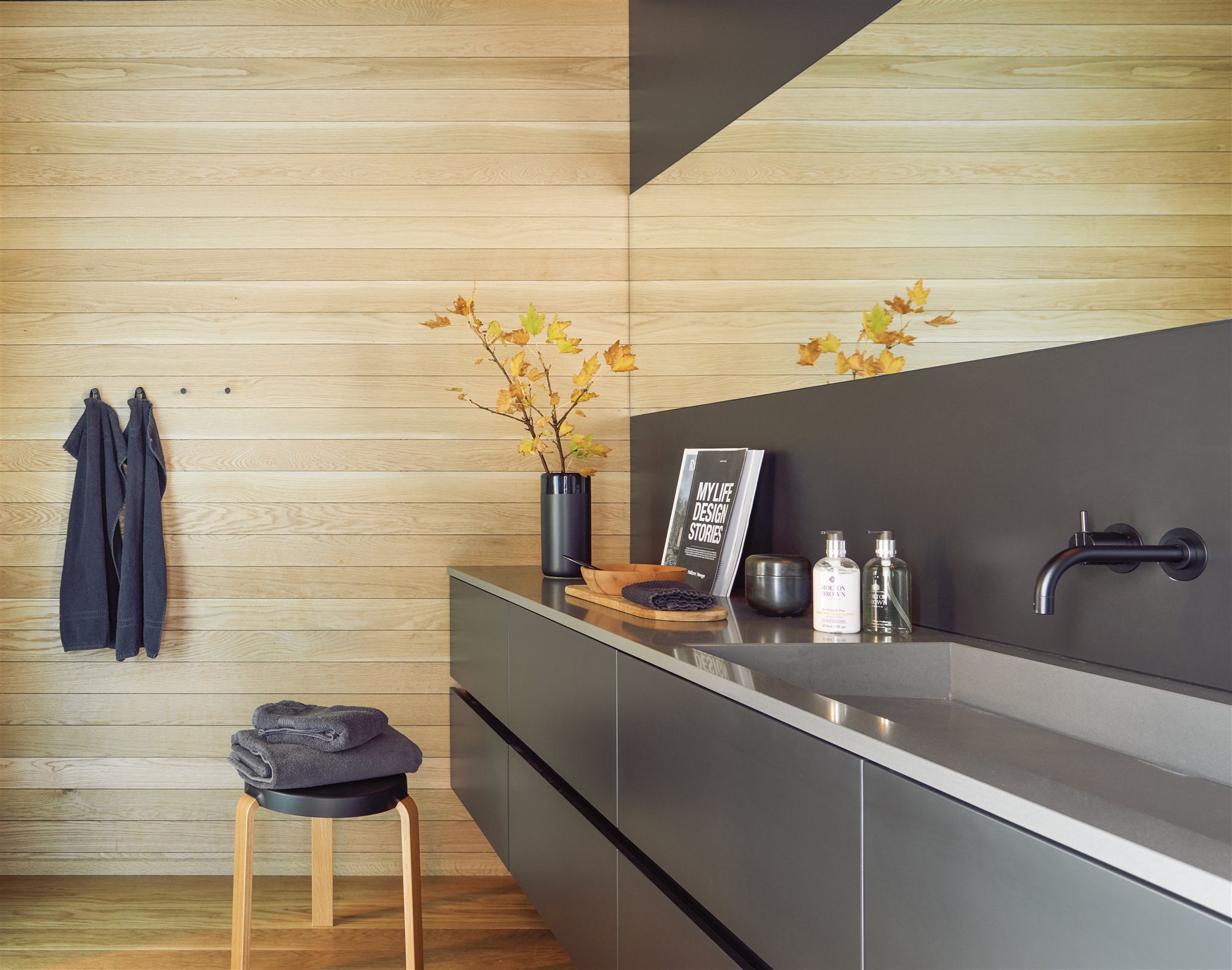 baño con muebles de color negro y toallas oscuras