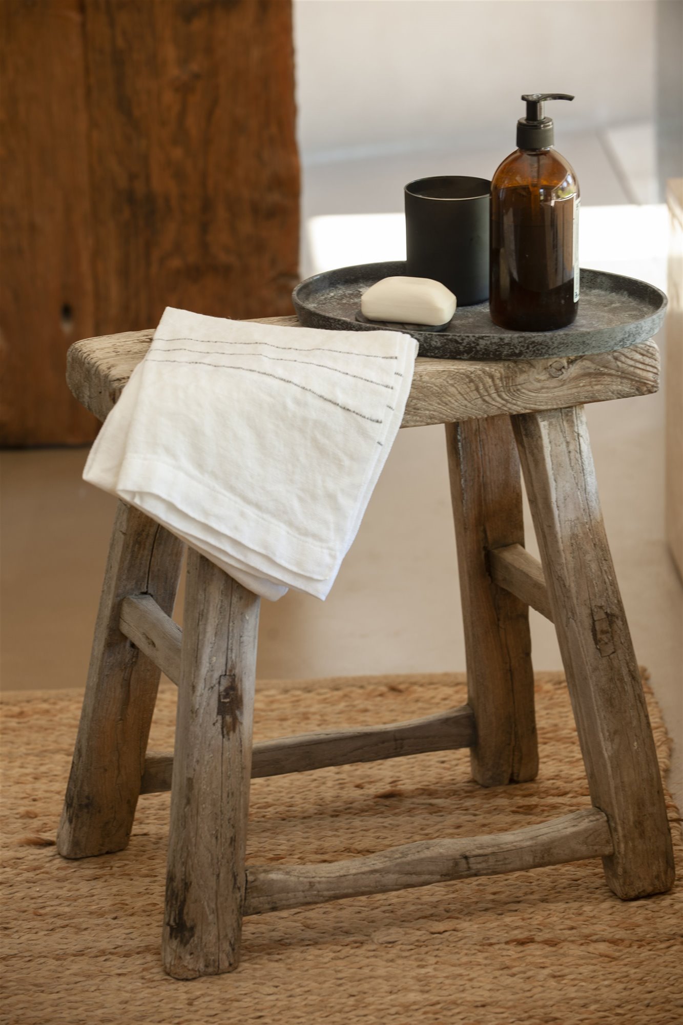 Taburete de estilo rustico con una toalla blanca. Cómo guardarlas