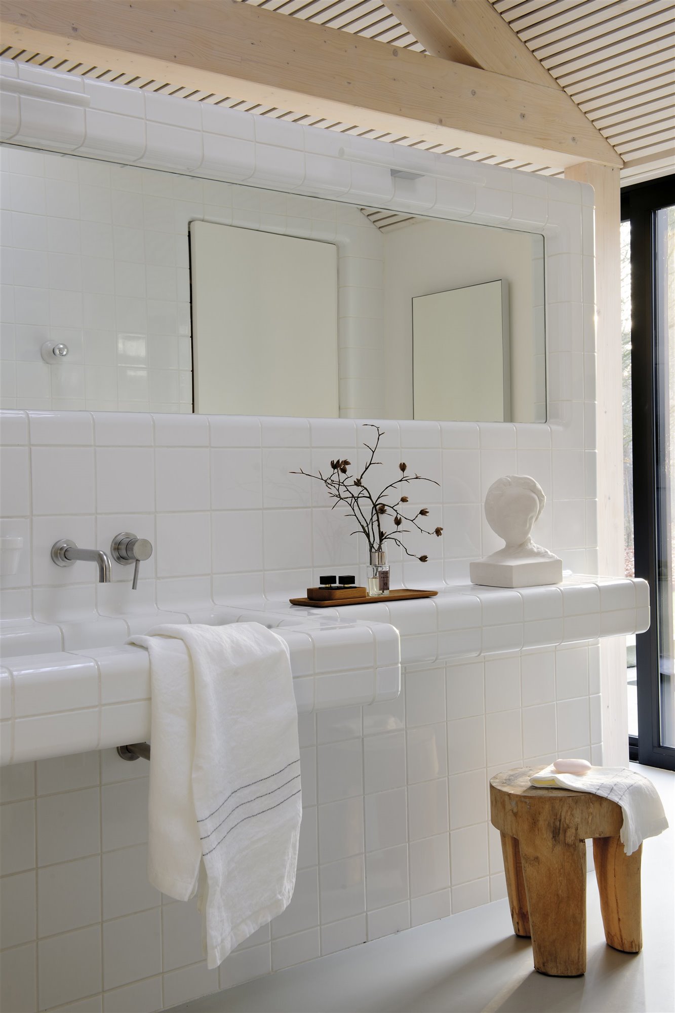 Baño con baldosas blancas y toalla blanca. De lavabo