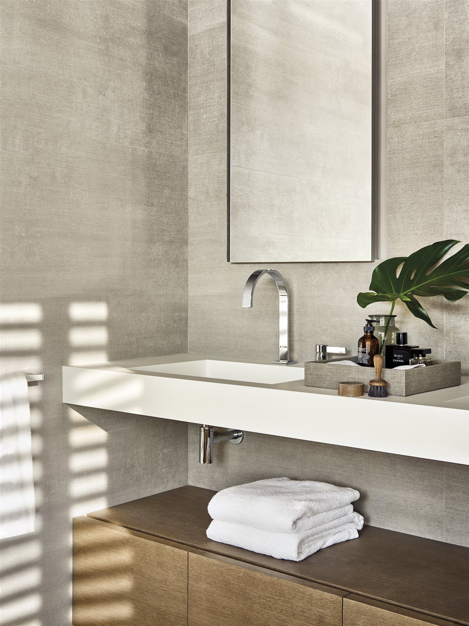 Baño con mueble bajolabavo con toallas blancas. De tocador