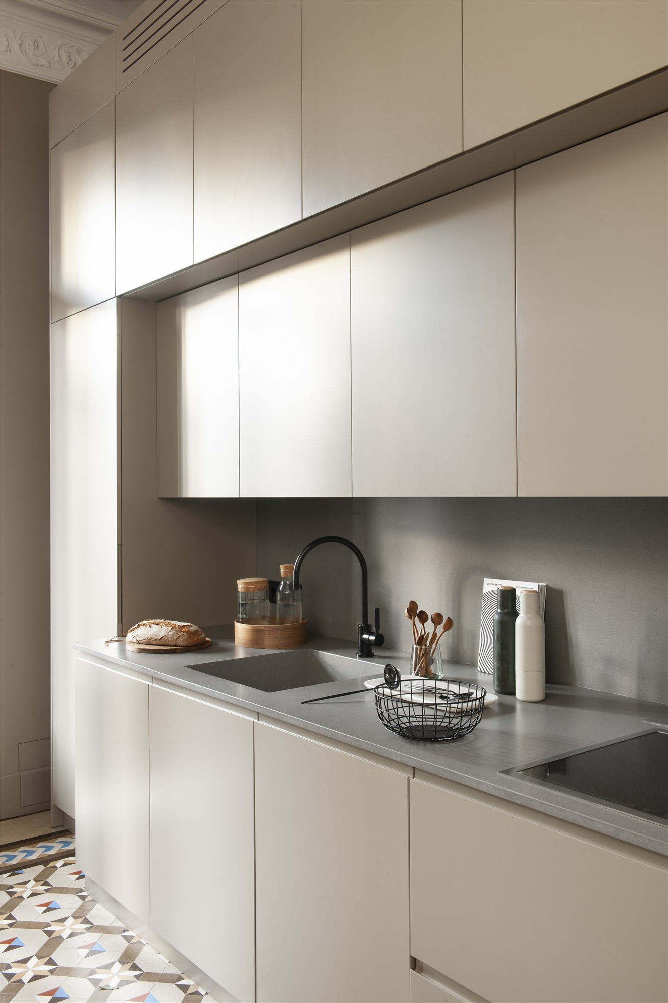 Cocina con muebles en color beige y suelo hidraulico con encimera en color gris foto Pere Peris