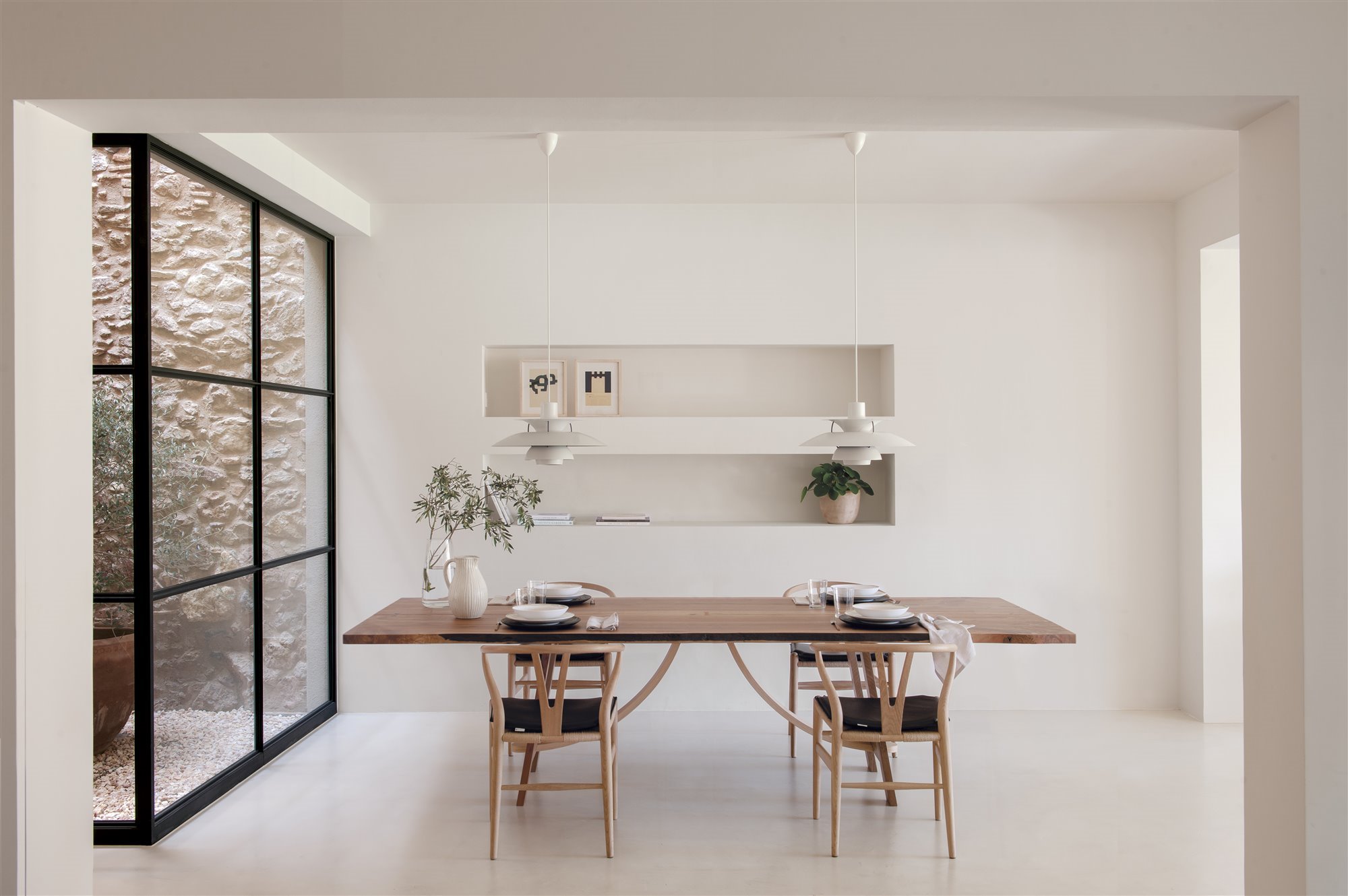 Comedor de una casa moderna con paredes de piedra foto Pere Peris