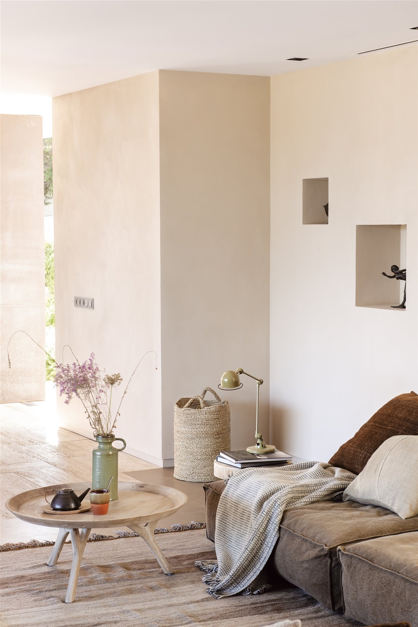 Salon con paredes pintadas a la cal y sofa de color gris foto Pere Peris