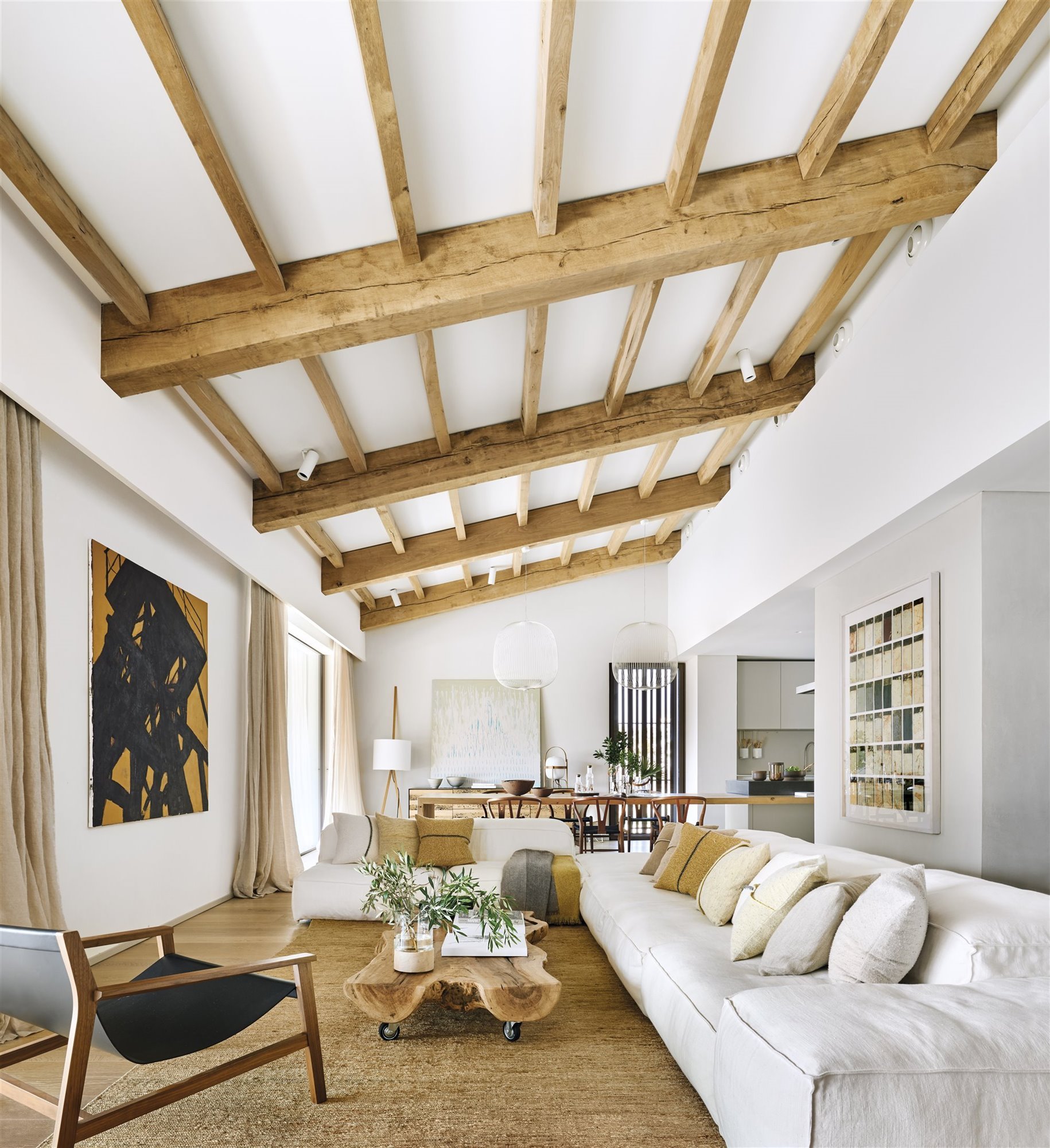 Salon de una casa moderna con vigas de madera vistas y sofá blanco