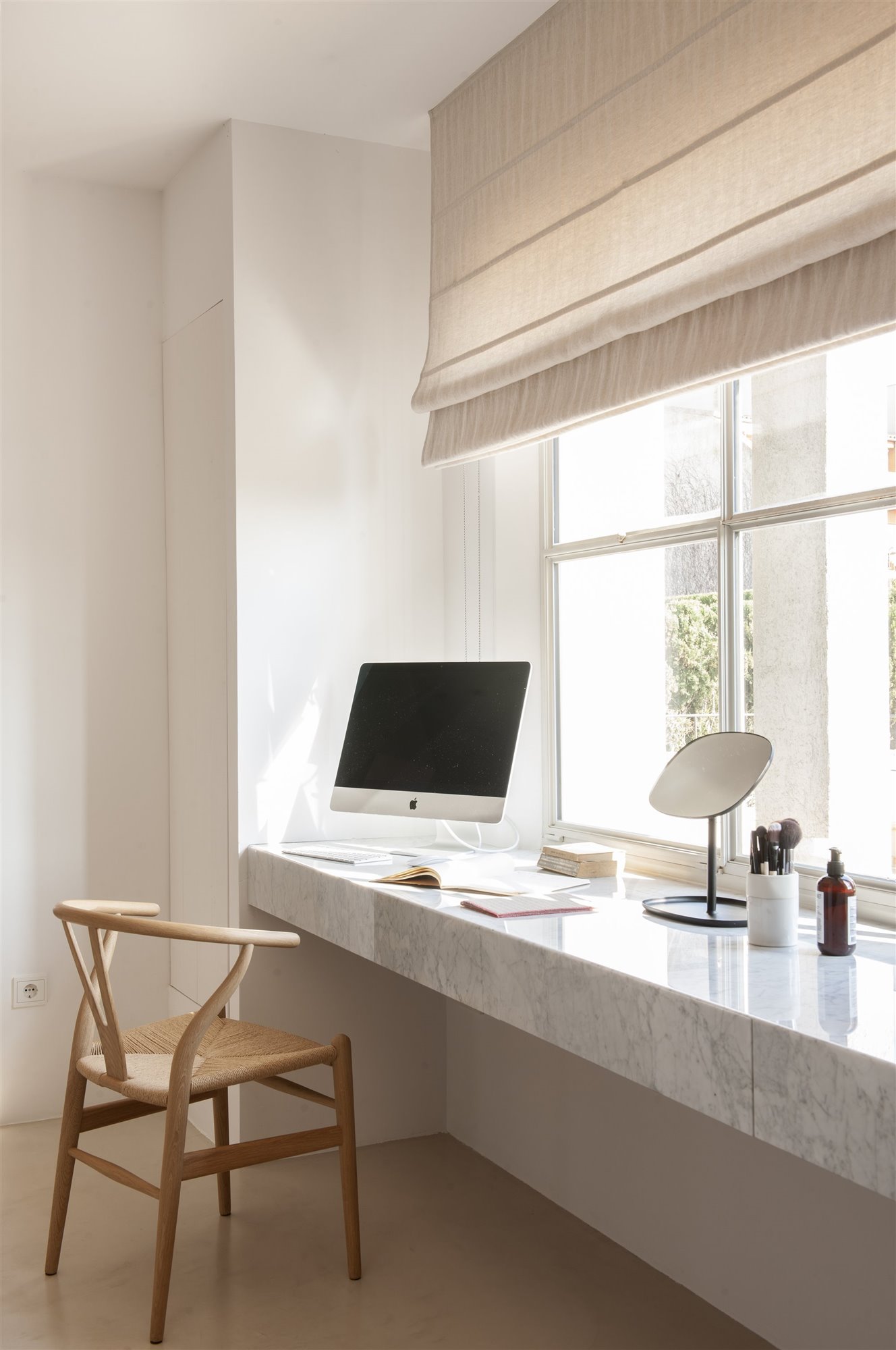 Zona de trabajo con ordenador espejo y productos de limpieza