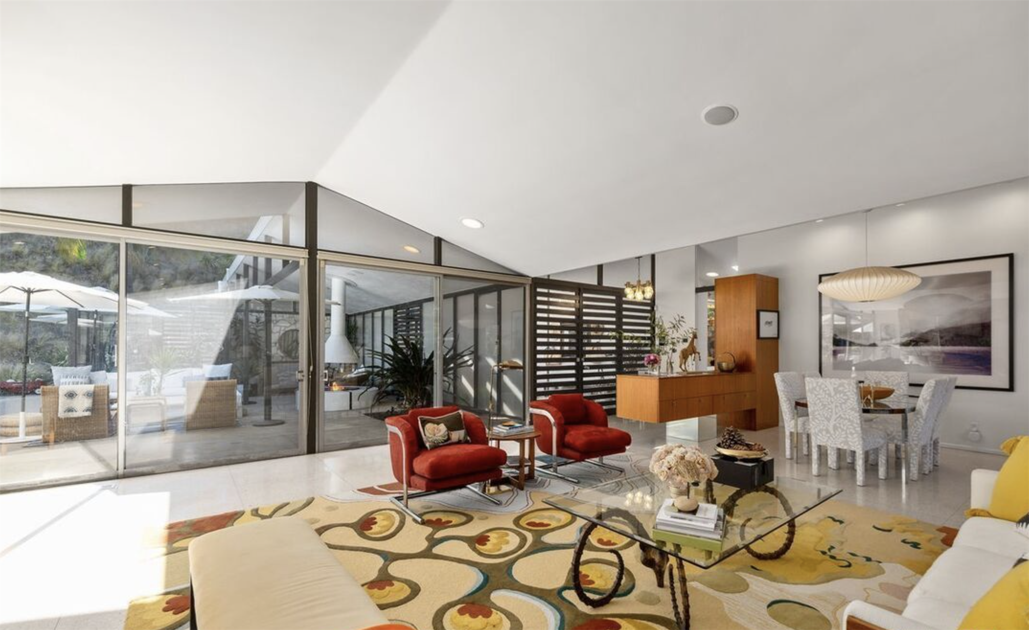 Casa de la actriz de la serie Modern Family Julie Bowen salon con sillones rojos y mesa de cristal