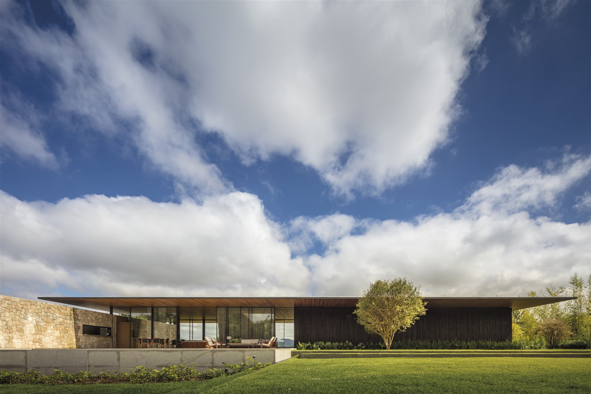 Casa de madera en Brasil rodeada de bosques fachada con comedor exterior