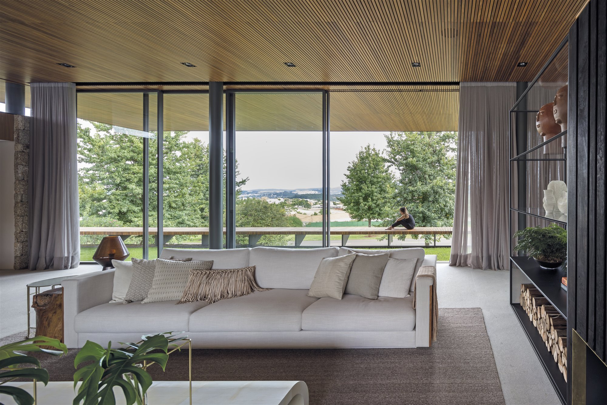 Casa de madera en Brasil rodeada de bosques salon con sofa blanco