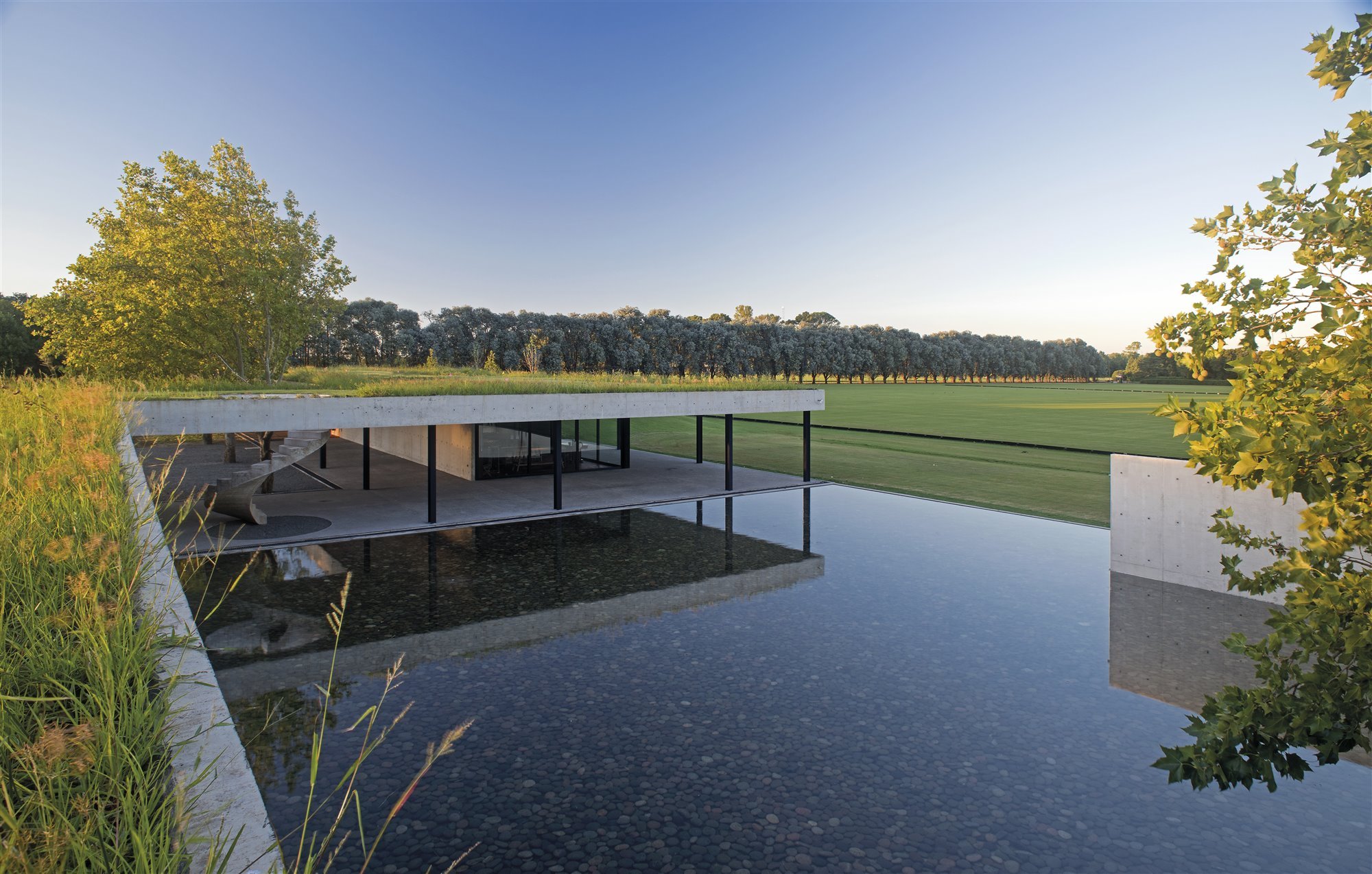 Casa moderna en Argentina con techos de hierba y muros de hormigón piscina