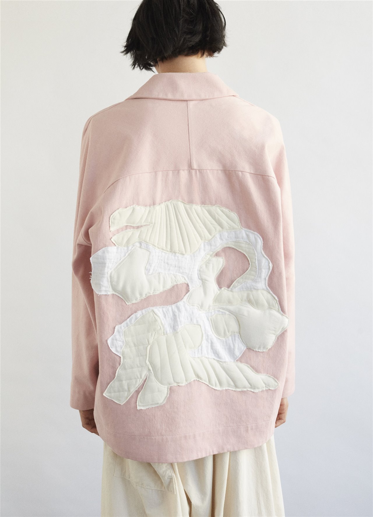 Chaqueta The Farrier rosa con bordado blanco.