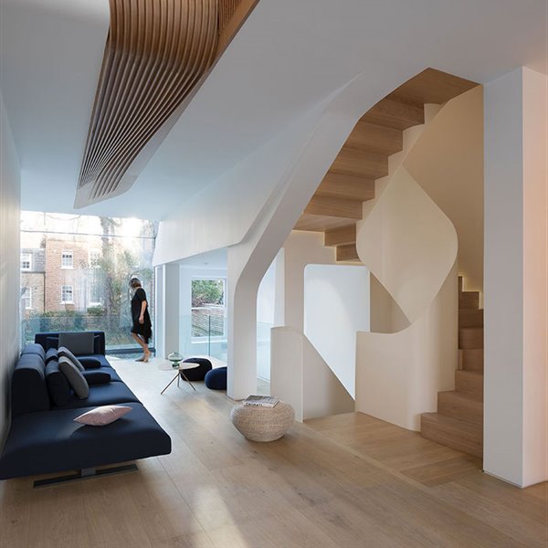 Salón con sofá en azul petróleo, estructura en blanco con suelo de madera, poufs en azul y cerramiento de cristal hacia exterior