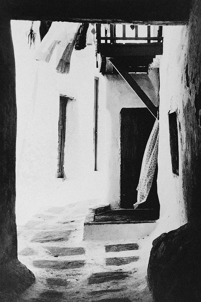 Callejón de piedra con las paredes encaladas en blanco.