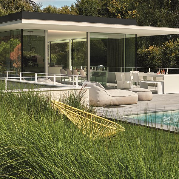 Casa de Bruno Erpicum con dos butacas Acapulco en primer plano y los sofás Float, de Francesco Rota para Paola Lenti, junto a la piscina.