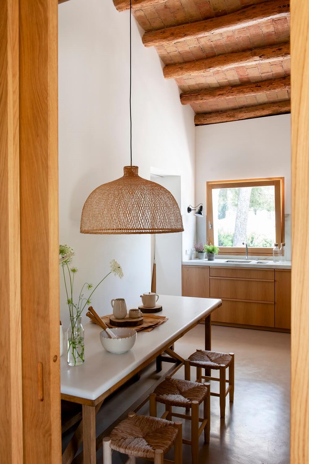 Cocina con office con lámpara de mimbre en cocina rústica y cubierta catalana.