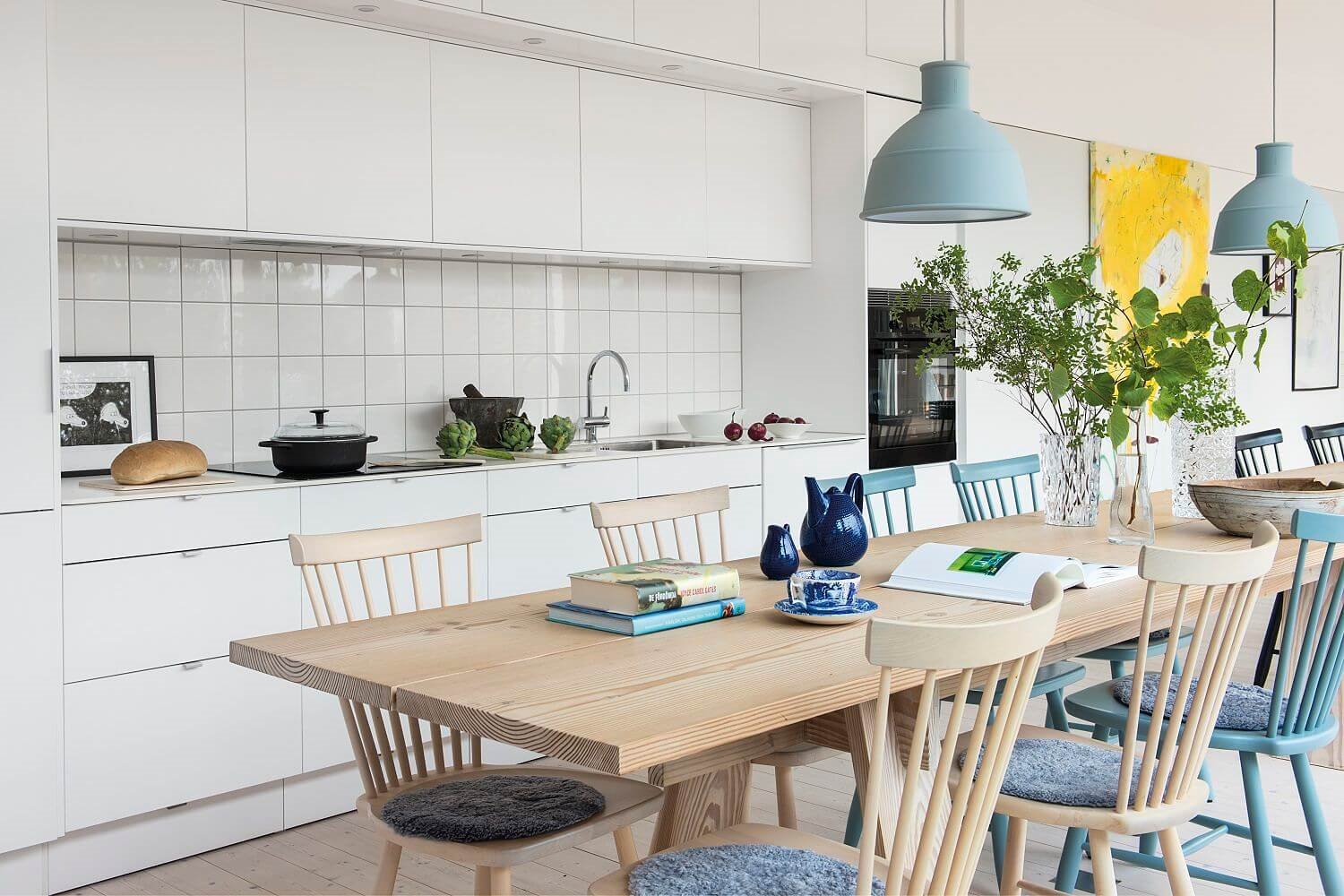 Mesa de madera con sillas y lámparas de colores