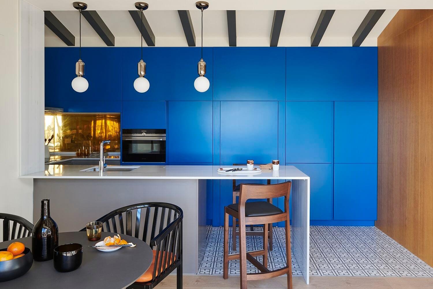 Cocina con muebles azules con vigas a la vista y baldosas hidráulicas vinílicas