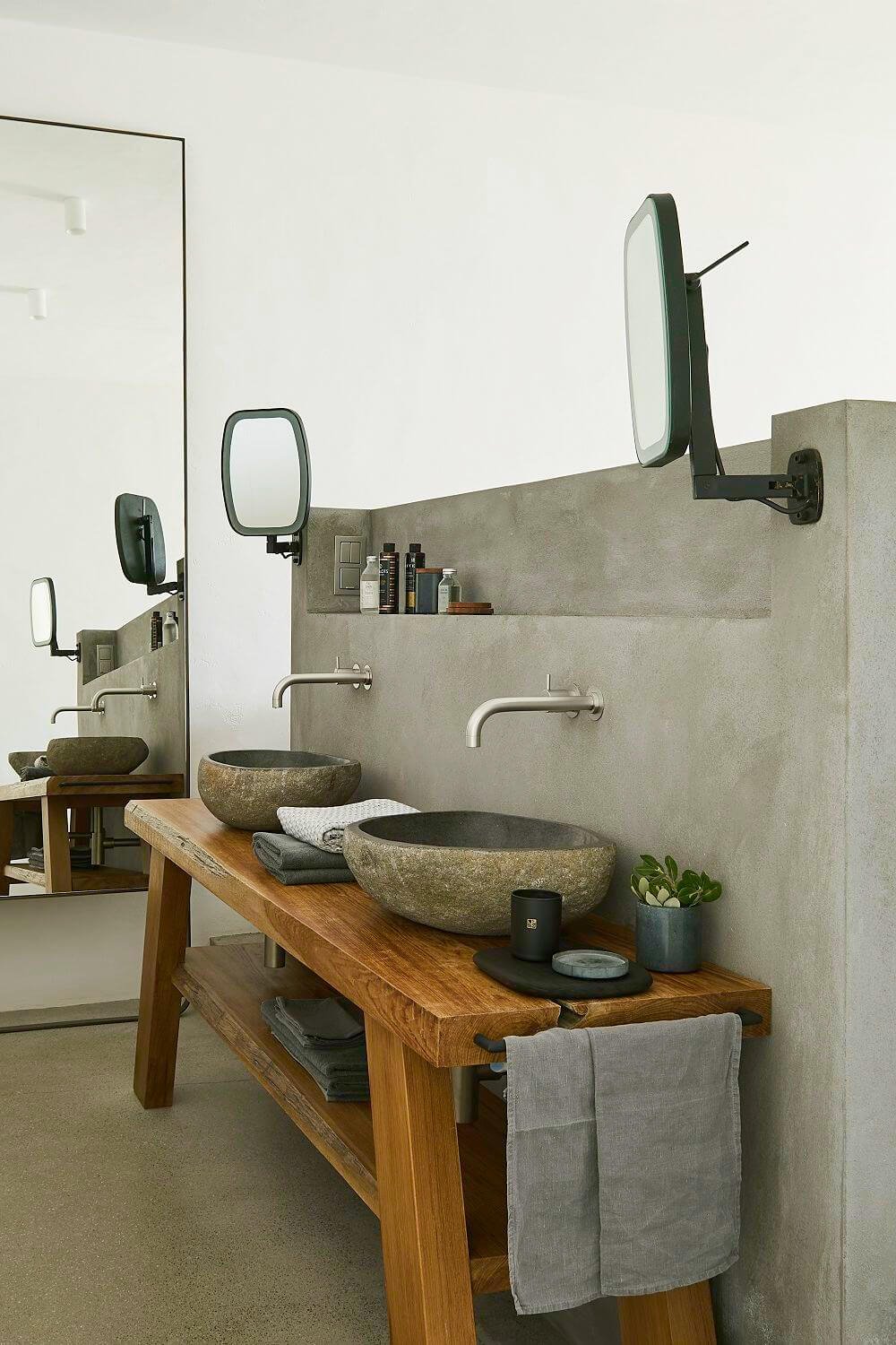 Mueble de baño de madera con lavabos exentos y estantería de microcemento.