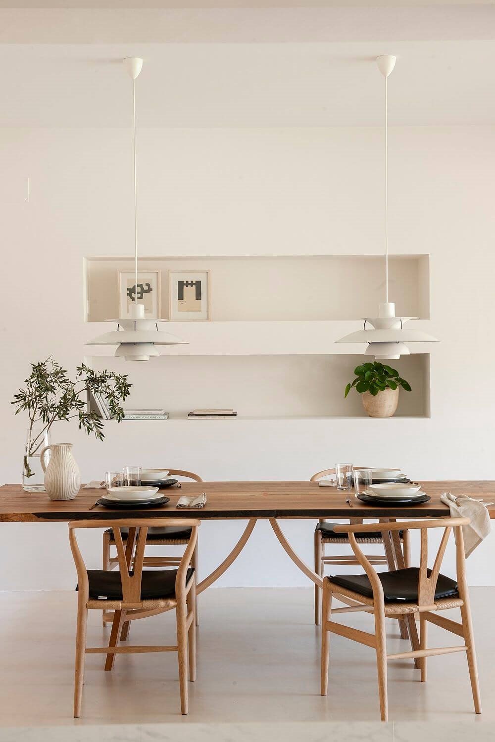 Lámparas de techo PH5 en comedor blanco y mesa y sillas de madera
