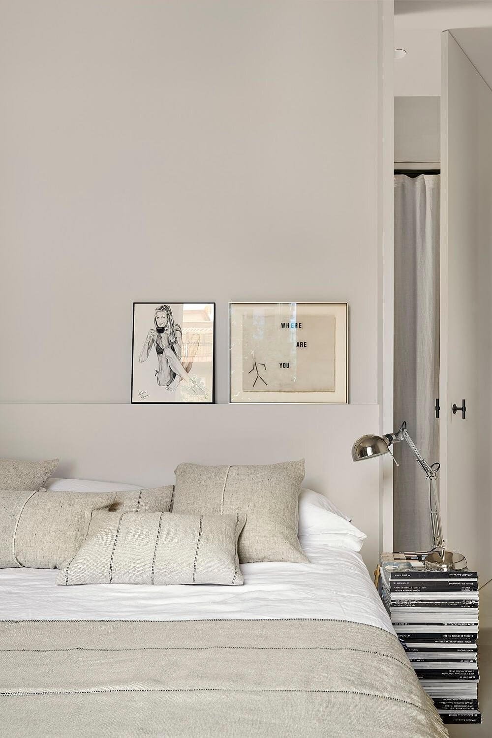 Dormitorio gris con libros como mesita de noche