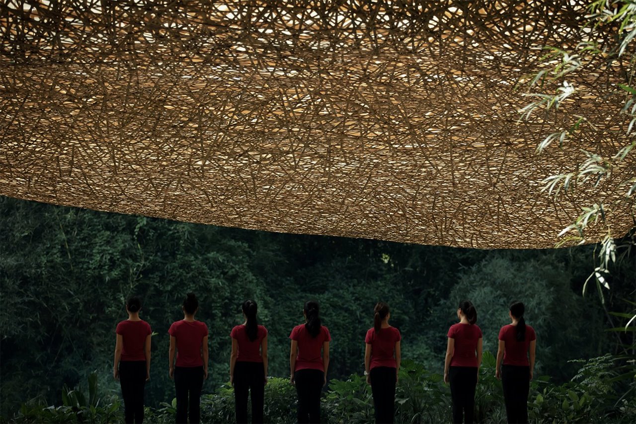Actrices del Impression Sanjie Liu bajo el techo de bambú de la estructura creada por llLab.