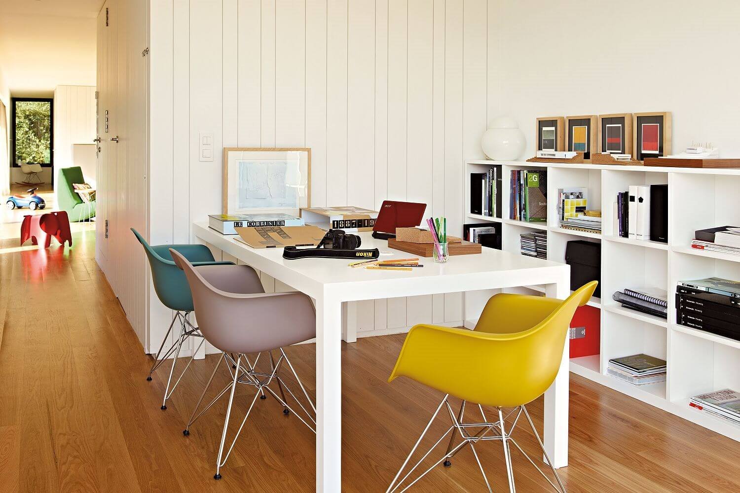 Despacho con mesa blanca y sillas de colores