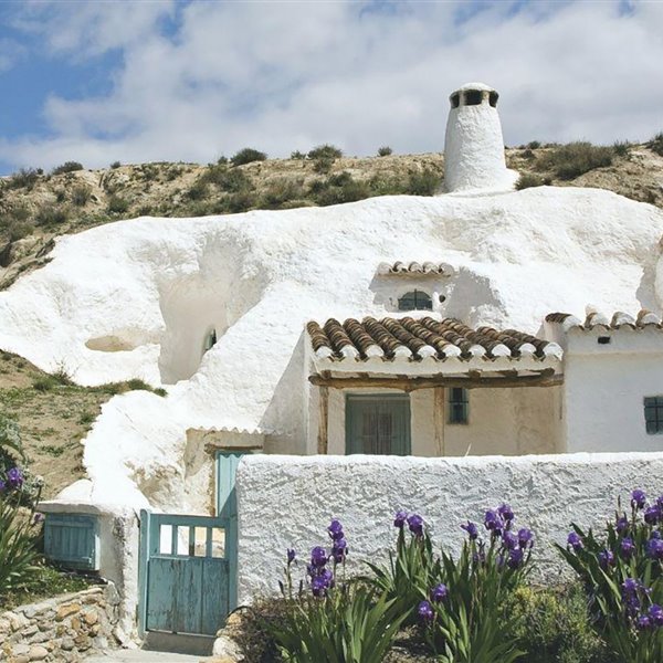 Una casa cueva con su fachada encalada en blanco en la localidad de Guadix. 