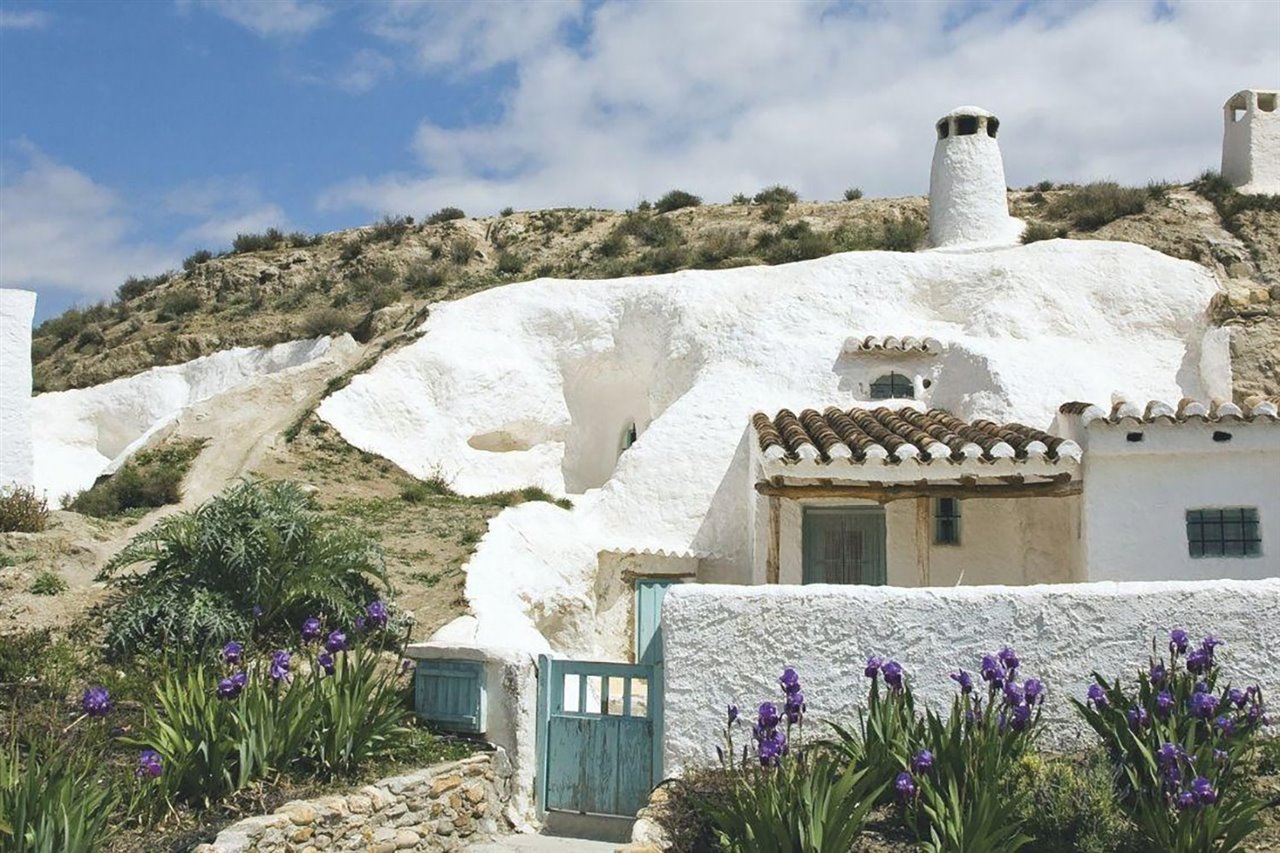 Una casa cueva con su fachada encalada en blanco en la localidad de Guadix. 