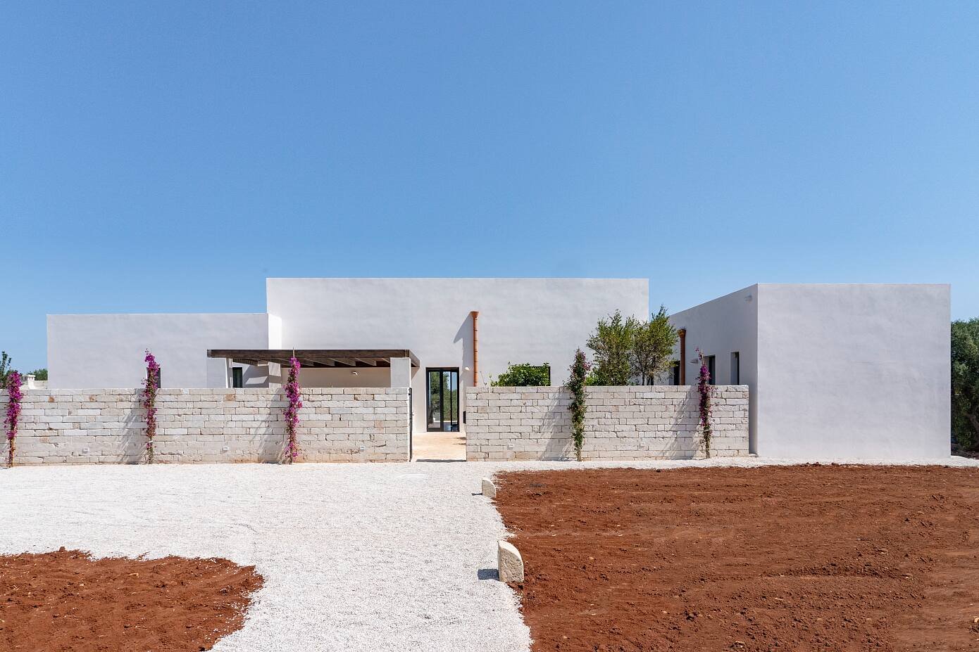 Casa en Italia con fachada de color blanco entrada con buganvilias