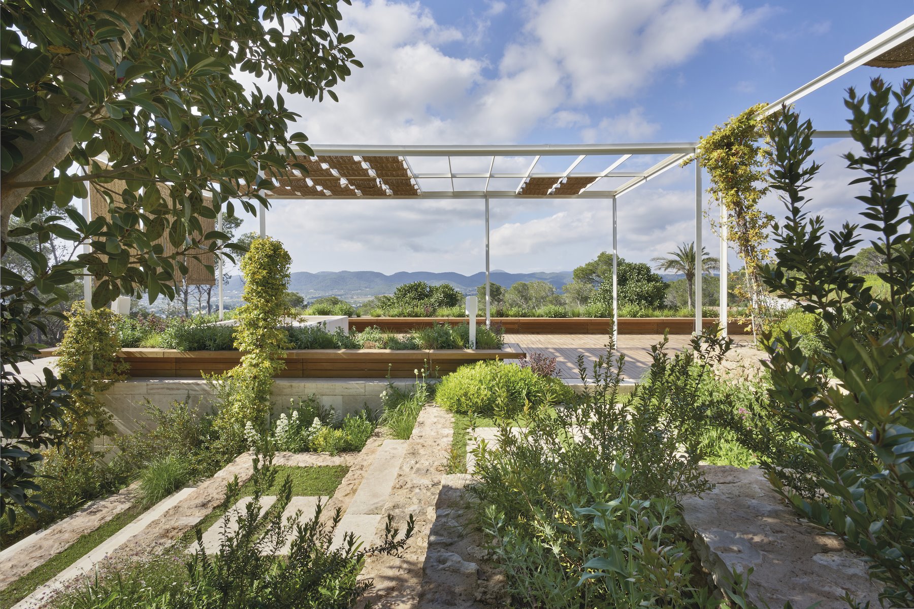 Casa moderna en Ibiza con fachada blanca y jardines con porches