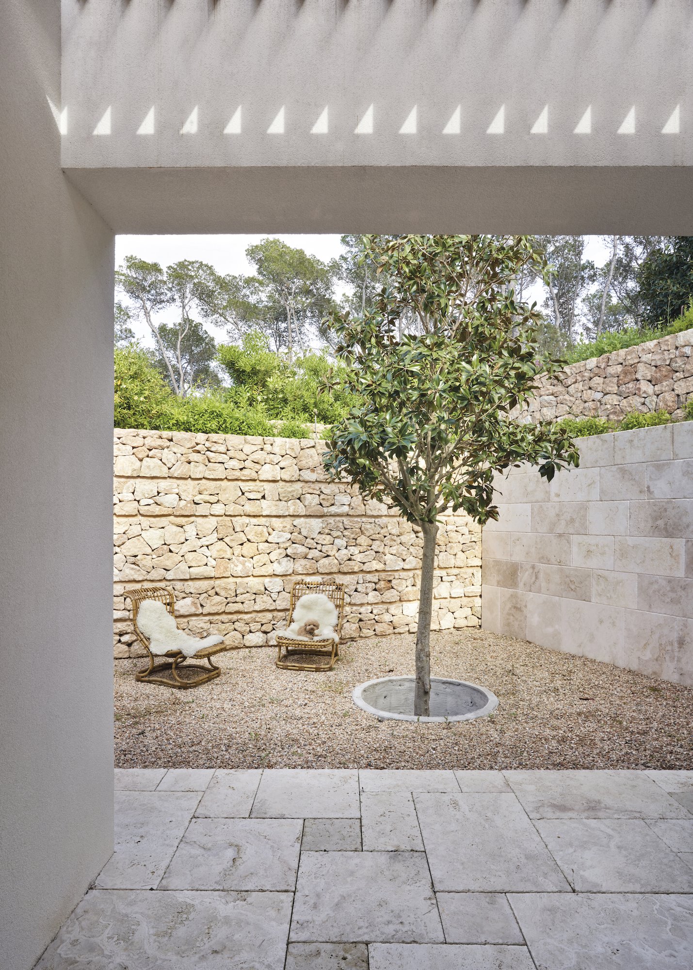 Casa moderna en Ibiza con fachada blanca y jardines muros de piedra