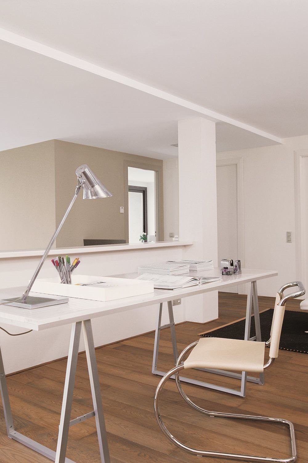 Espacio de trabajo con mesa y silla blanca y lámpara