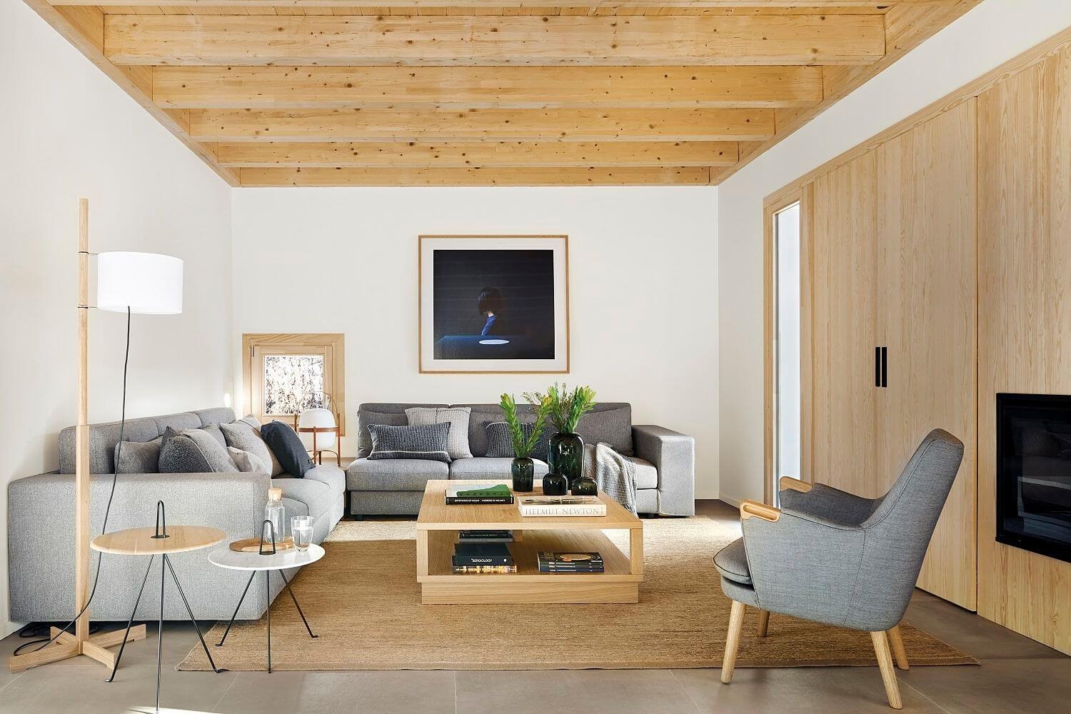 salón con sofás grises y butaca gris con patas de madera
