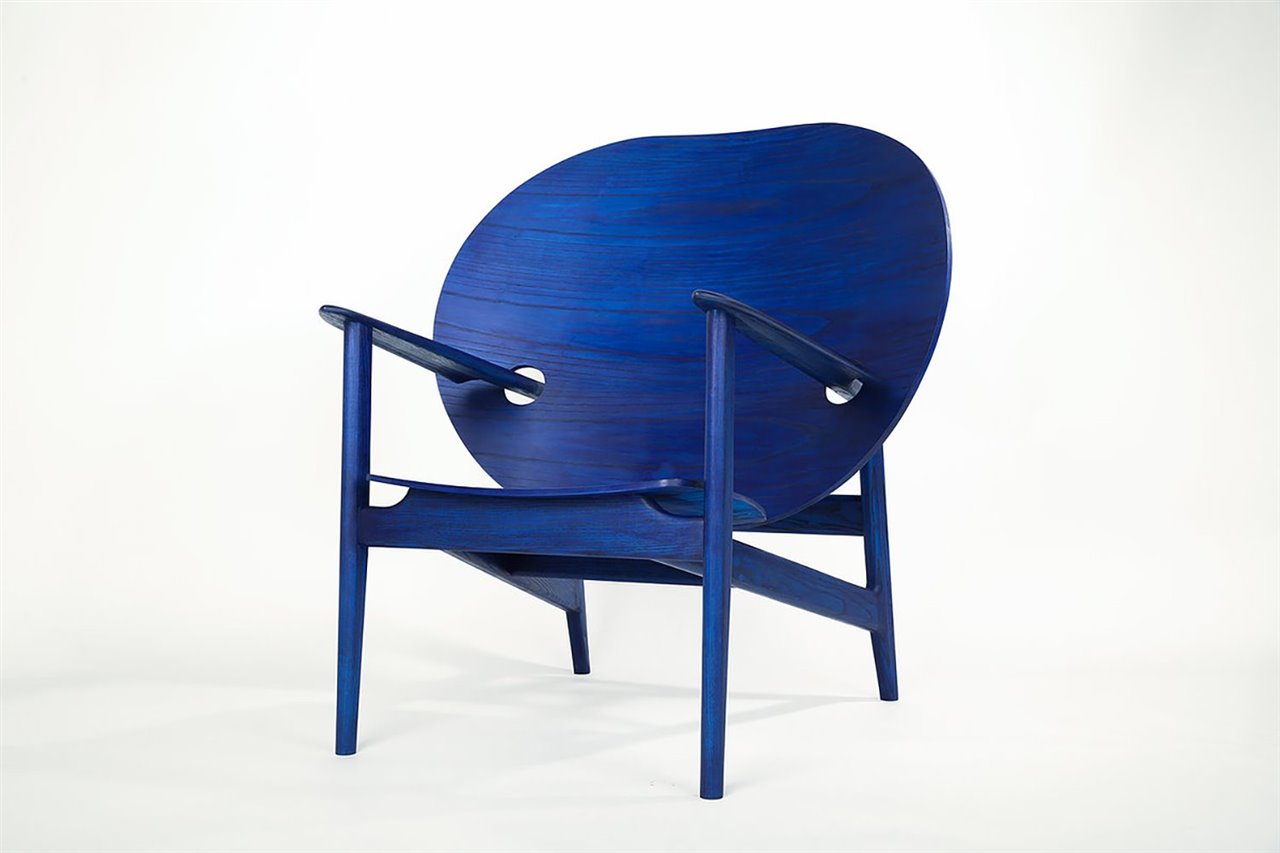 La original silla-trono Iklwa en madera pintada de azul índigo que honra a los ancestros del diseñador Mac Collins.