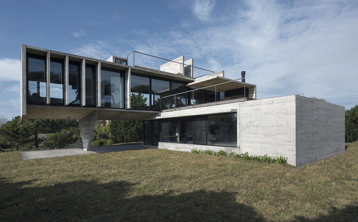 exterior-con-estructura-de-hormigon-en-forma-de-l-con-los-dos-niveles-de-la-vivienda-asentada-en-zona-ajardinada ecc86232 1500x930