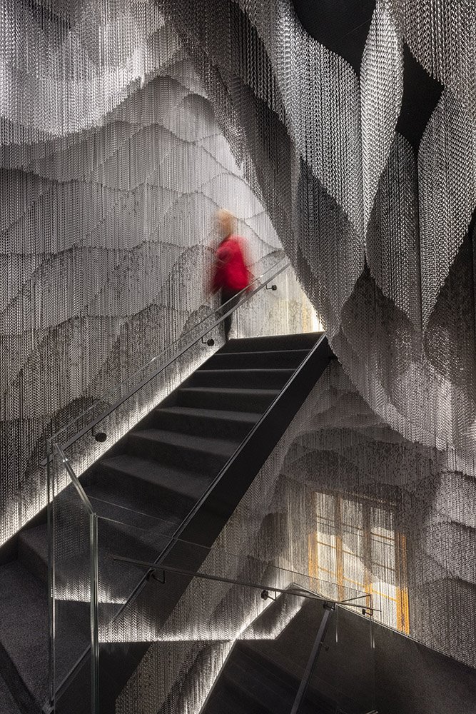 La instalación de Kengo Kuma utiliza 164.000 metros de cortina de aluminio Kriskadecor para vestir la escalera que comunica todas las plantas del edificio.