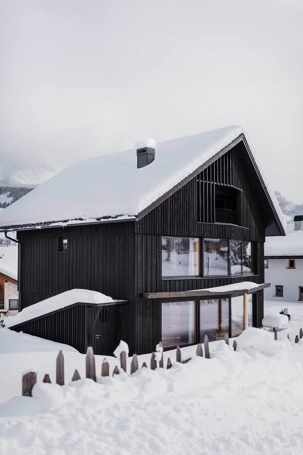 Moderno refugio de madera fachada nevada