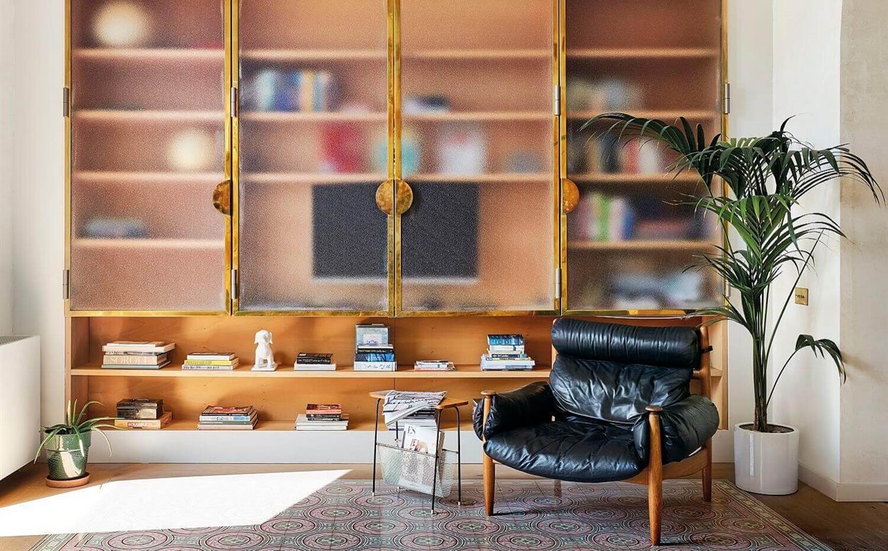 Grupos de libros y pequeñas esculturas se intercalan en una librería para lograr un resultado equilibrado.