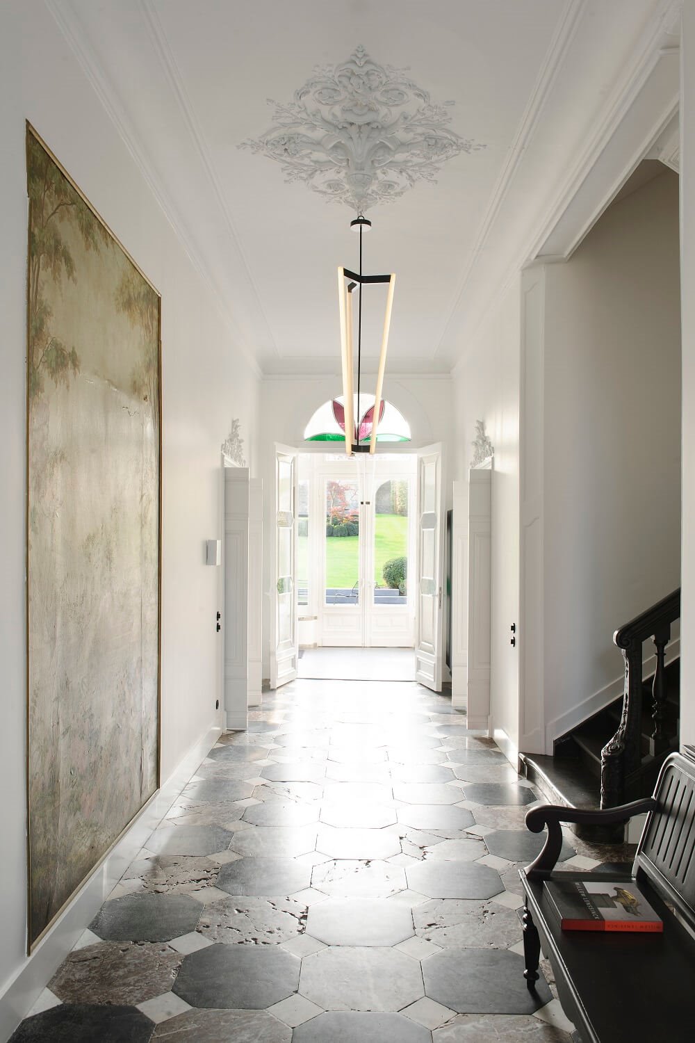 La mezcla de estilos también es un acierto en los recibidores grandes. Un suelo clásico y con historia se complementará muy bien con una lámpara ligera de diseño actual.