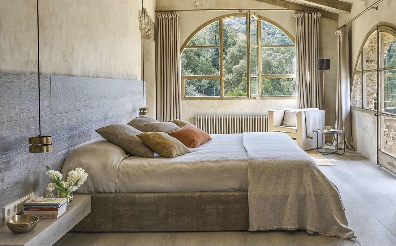 La madera es la absoluta protagonista de este dormitorio, que presenta un cabecero de grandes dimensiones de lado a lado.