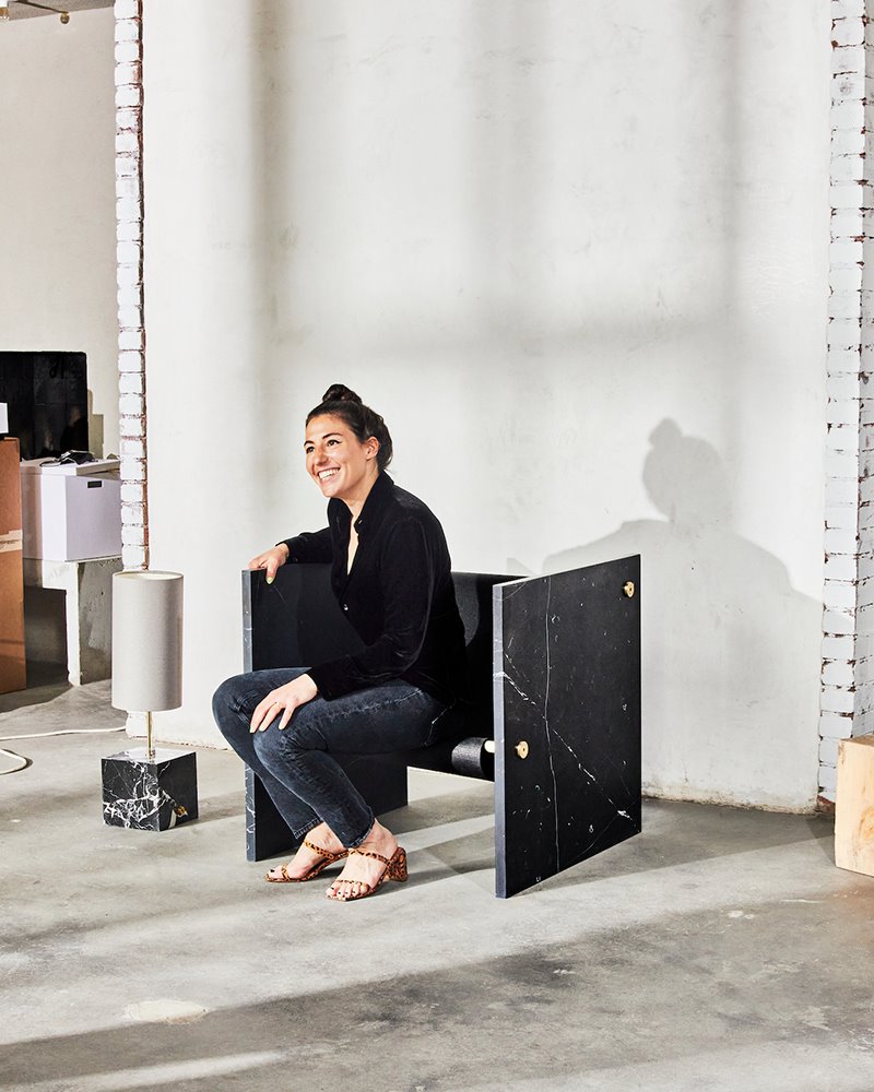 Arielle Assouline Lichten posa sentada en su silla Adri fabricada en mármol negro.